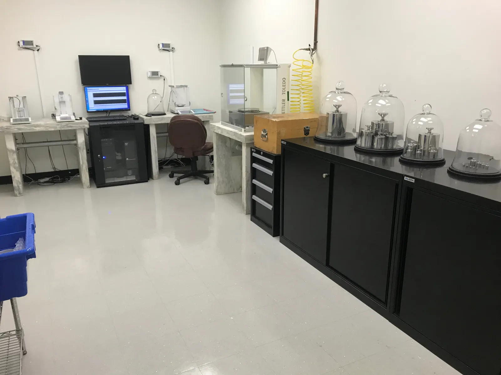American Gage mass laboratory with Mettler comparators on isolation tables and Class 1 stainless weight sets under glass domes